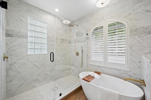 bathroom with separate shower and tub and tile walls