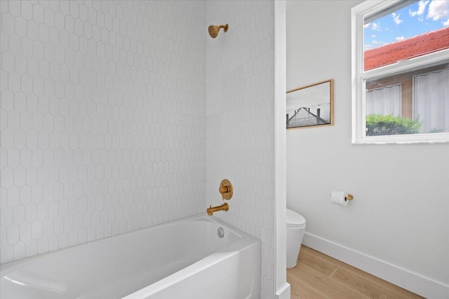 bathroom featuring hardwood / wood-style flooring, toilet, and shower / washtub combination