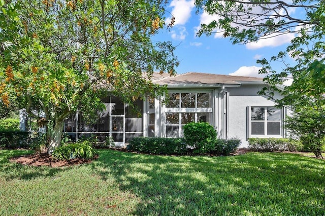 rear view of house with a lawn and a sunroom