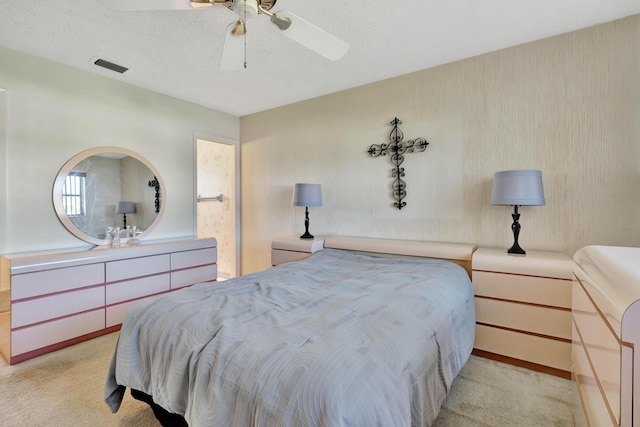 carpeted bedroom featuring ceiling fan and a textured ceiling