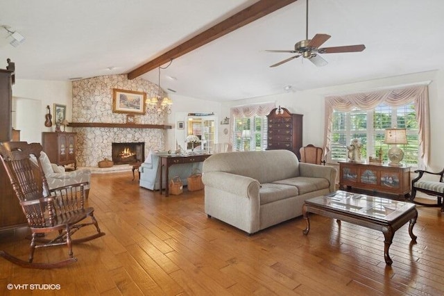 living room with a stone fireplace, ceiling fan, lofted ceiling with beams, and hardwood / wood-style flooring