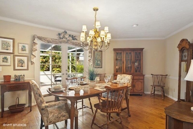 dining area featuring hardwood / wood-style flooring, an inviting chandelier, and crown molding