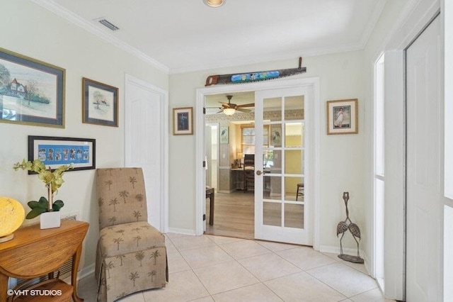 sitting room with ceiling fan, ornamental molding, light tile patterned floors, and french doors