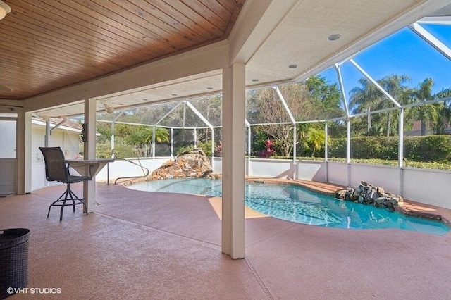 view of swimming pool featuring glass enclosure and a patio area