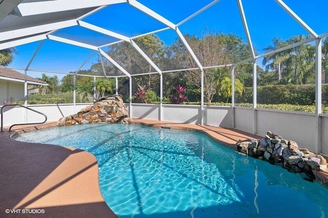 view of pool featuring glass enclosure and a patio area