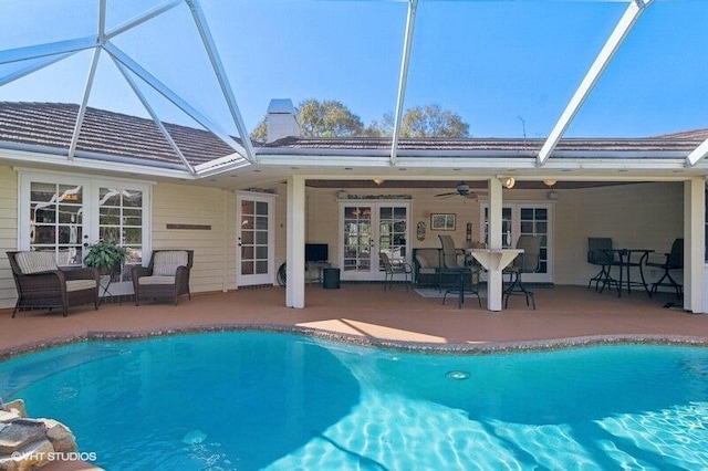 view of pool featuring french doors, a lanai, ceiling fan, and a patio area