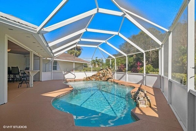 view of pool featuring glass enclosure and a patio