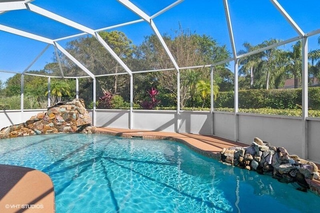 view of swimming pool featuring a lanai