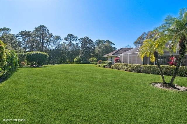 view of yard with glass enclosure