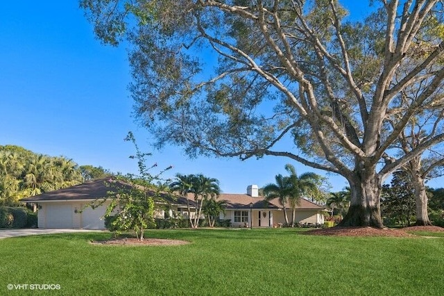 single story home featuring a front lawn and a garage