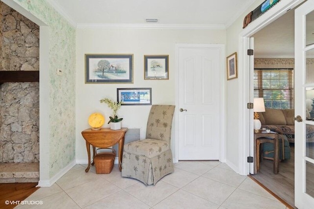 sitting room featuring crown molding and light tile patterned floors