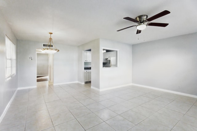 spare room with ceiling fan and light tile patterned floors