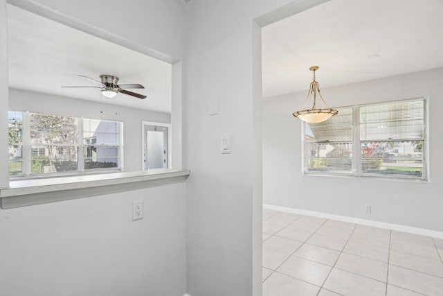 tiled spare room featuring ceiling fan