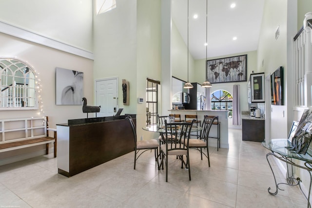 dining area featuring a high ceiling and light tile patterned floors