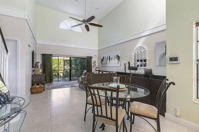 dining area featuring light tile patterned flooring, ceiling fan, and high vaulted ceiling