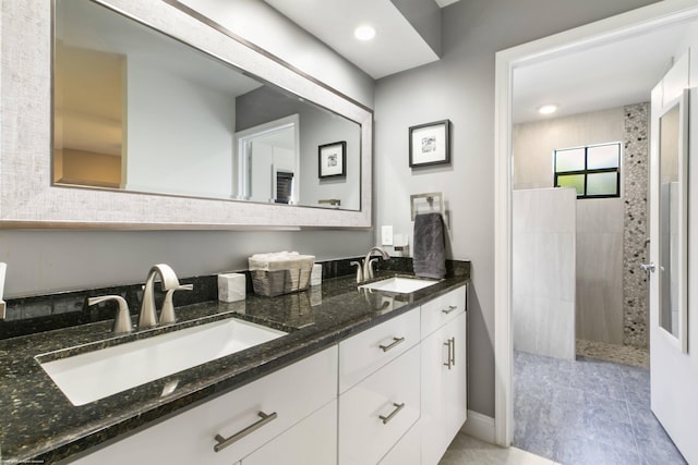 bathroom featuring a tile shower and vanity