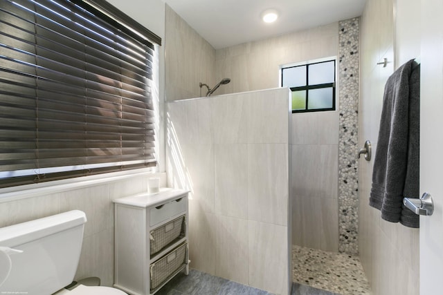 bathroom featuring a tile shower and toilet