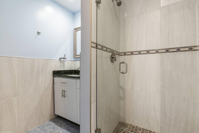 bathroom featuring tile walls, vanity, and walk in shower