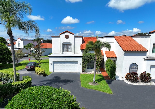 mediterranean / spanish-style house featuring a garage and a front yard