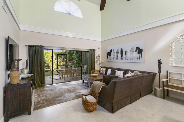 living room featuring light tile patterned flooring, ceiling fan, and a high ceiling