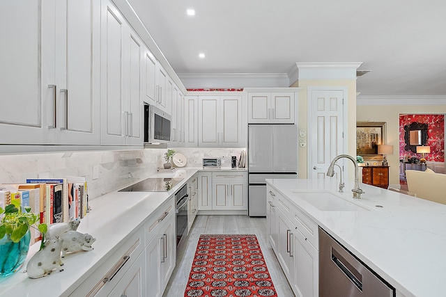 kitchen with backsplash, stainless steel appliances, crown molding, sink, and white cabinets