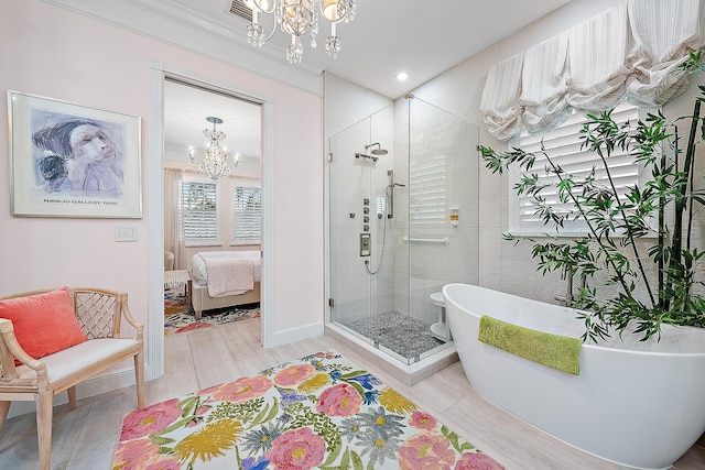 bathroom with a chandelier and shower with separate bathtub