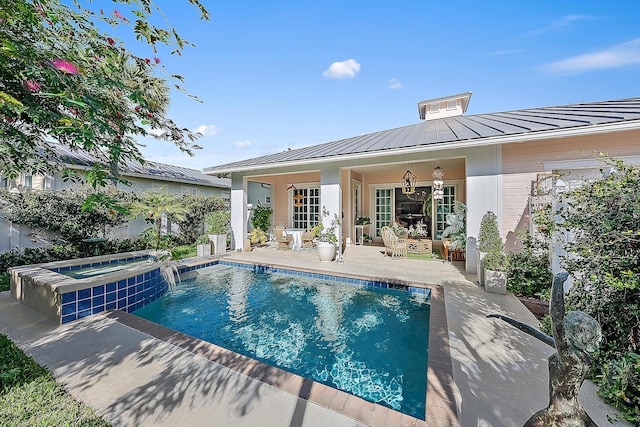 view of pool with pool water feature, a patio area, and an in ground hot tub