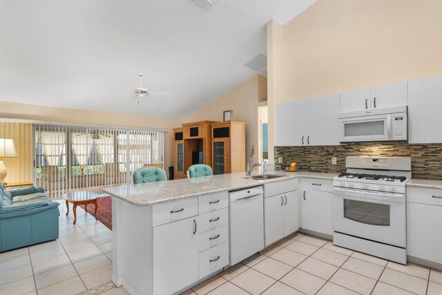 kitchen with white appliances, kitchen peninsula, and tasteful backsplash