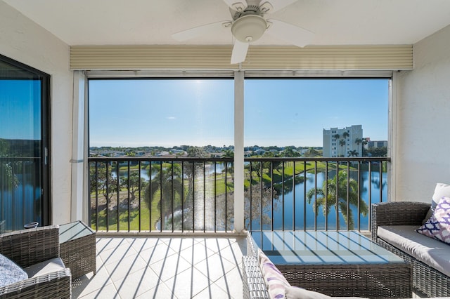 sunroom featuring a water view, ceiling fan, and a wealth of natural light