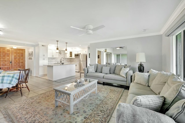 living room featuring ceiling fan, sink, light tile patterned flooring, and ornamental molding