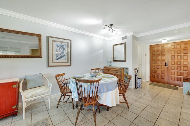 dining area with light tile patterned floors and ornamental molding