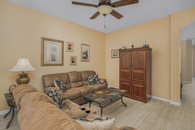 living room featuring ceiling fan and light hardwood / wood-style flooring