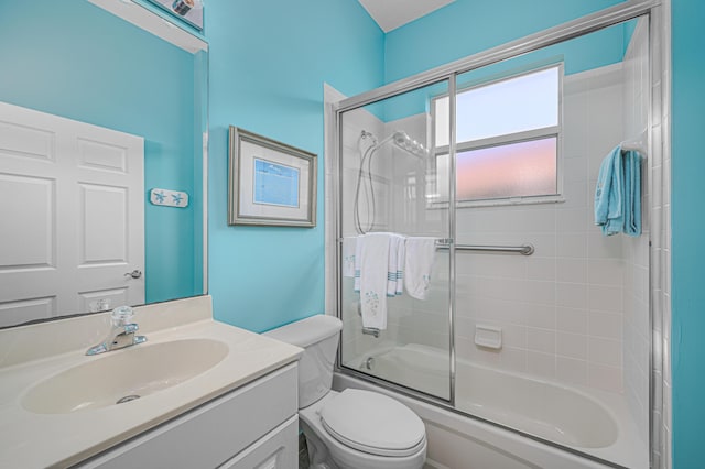 full bathroom featuring vanity, shower / bath combination with glass door, and toilet