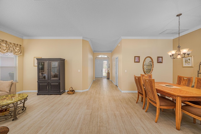 dining room with crown molding, plenty of natural light, an inviting chandelier, and light hardwood / wood-style floors