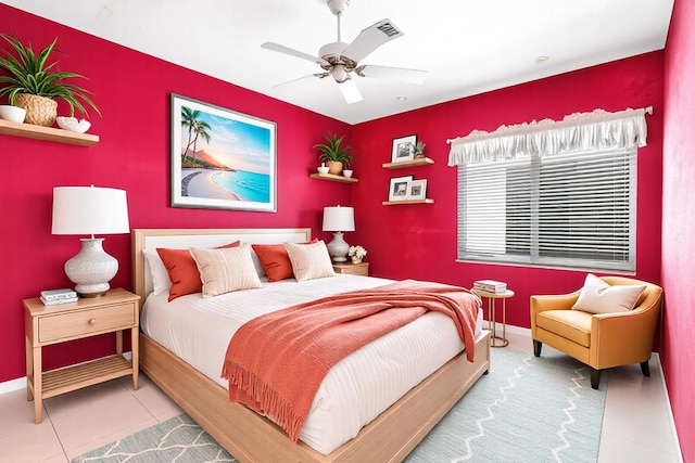 tiled bedroom with an accent wall, visible vents, baseboards, and a ceiling fan