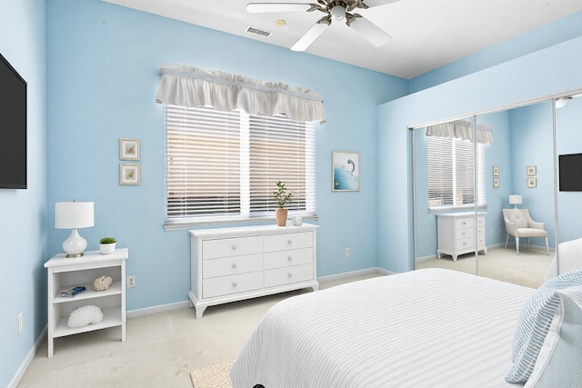 bedroom featuring a ceiling fan, light colored carpet, visible vents, and baseboards