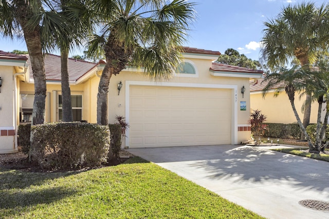 mediterranean / spanish house featuring a garage, driveway, a tile roof, and stucco siding