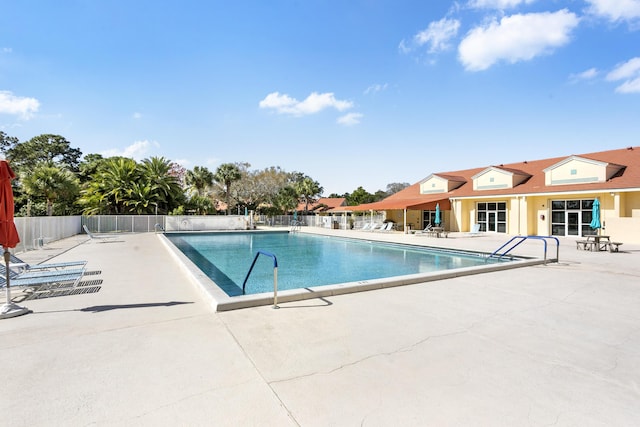 pool with a patio area and fence