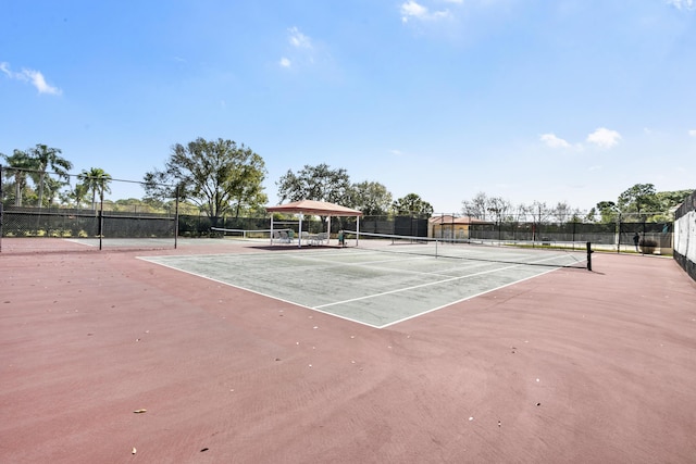 view of tennis court with fence and a gazebo