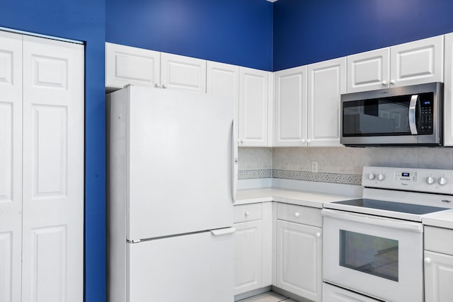 kitchen featuring white appliances, white cabinetry, and light countertops