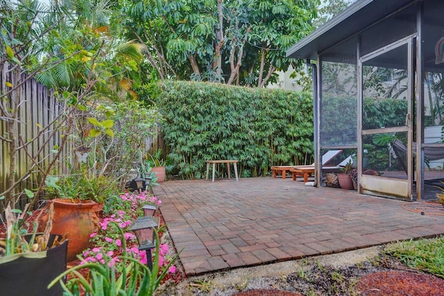 view of patio with a fenced backyard and a sunroom