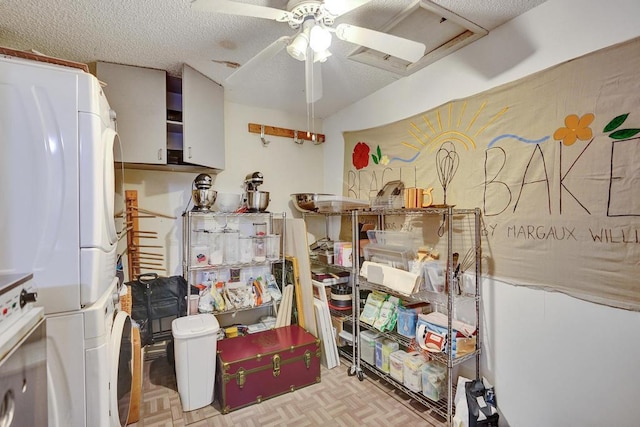 kitchen featuring stacked washer and dryer, light parquet floors, a textured ceiling, and ceiling fan