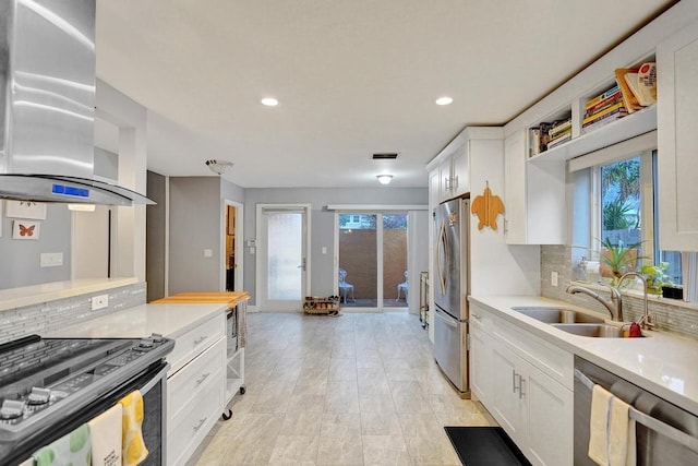 kitchen with decorative backsplash, stainless steel appliances, white cabinetry, a sink, and exhaust hood