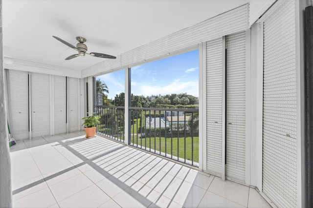 unfurnished sunroom with ceiling fan