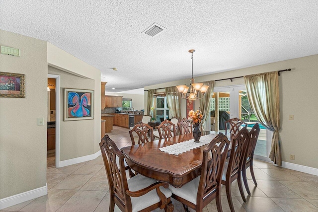 tiled dining area featuring a textured ceiling and a chandelier