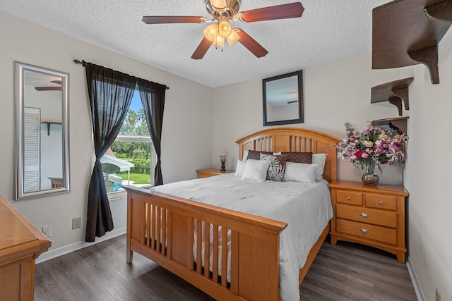 bedroom featuring a textured ceiling, ceiling fan, and dark wood-type flooring