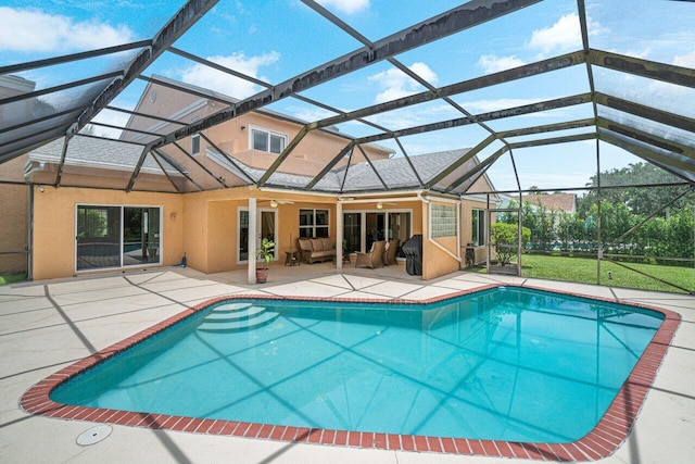 view of pool with outdoor lounge area, glass enclosure, ceiling fan, and a patio area