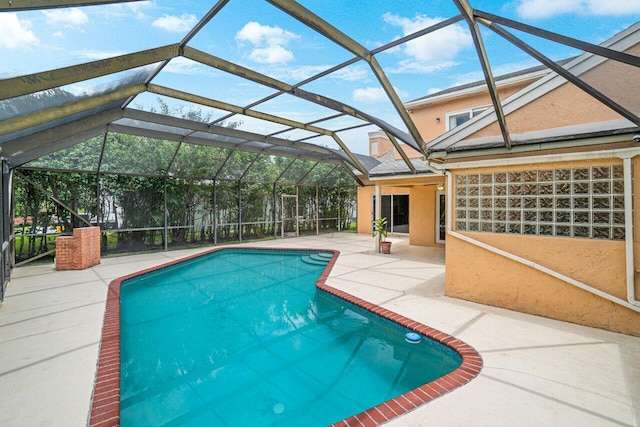 view of pool with glass enclosure and a patio