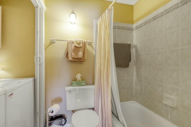 bathroom featuring toilet, shower / bath combo, and washer / dryer