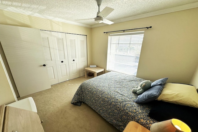 bedroom with a textured ceiling, ceiling fan, crown molding, carpet floors, and a closet